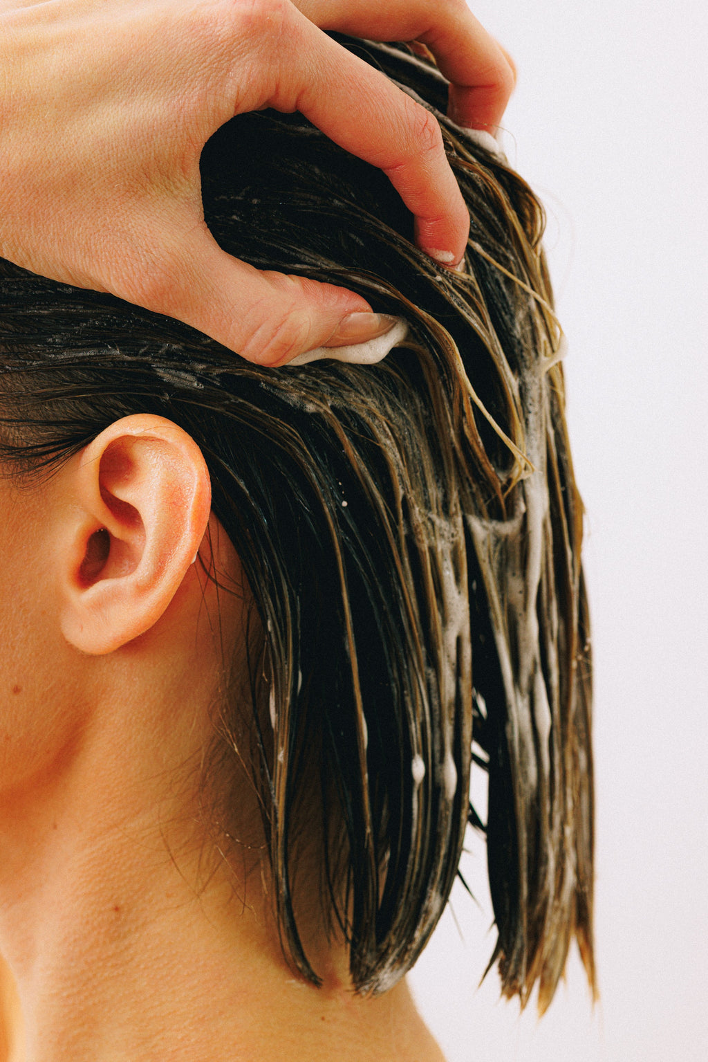 Conditioner wordt met de hand door nat haar verdeeld
